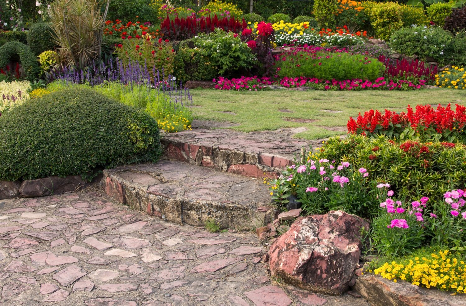 Giardino fiorito con camminamento in pietra naturale